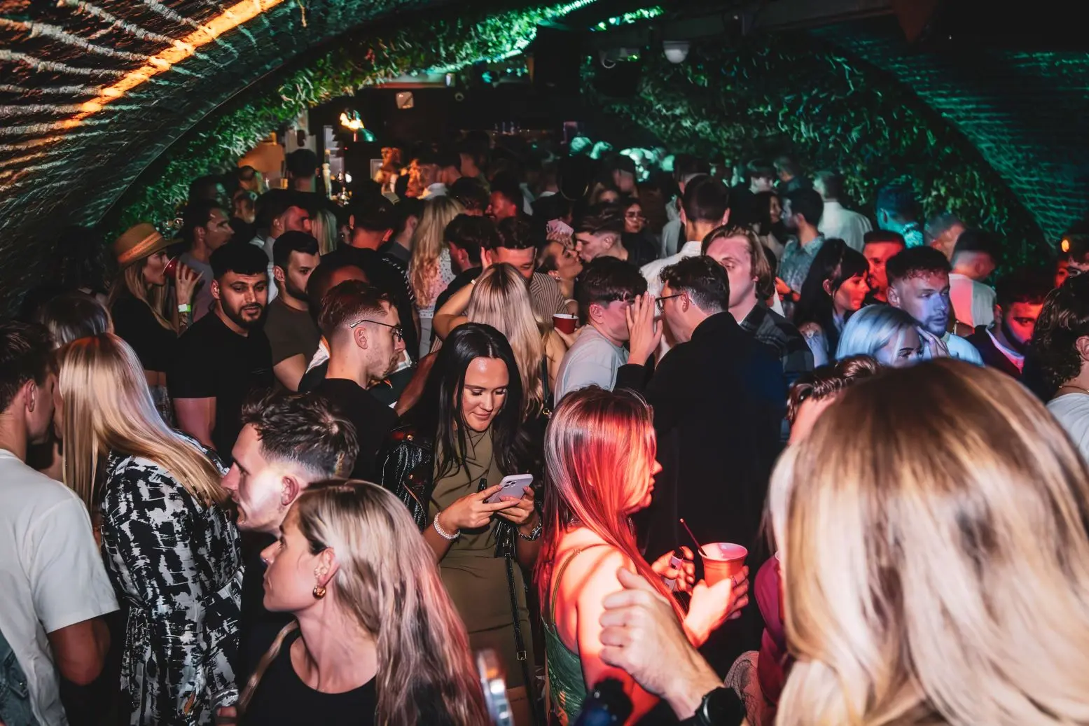 A vibrant nightclub scene with people dancing and colorful lights