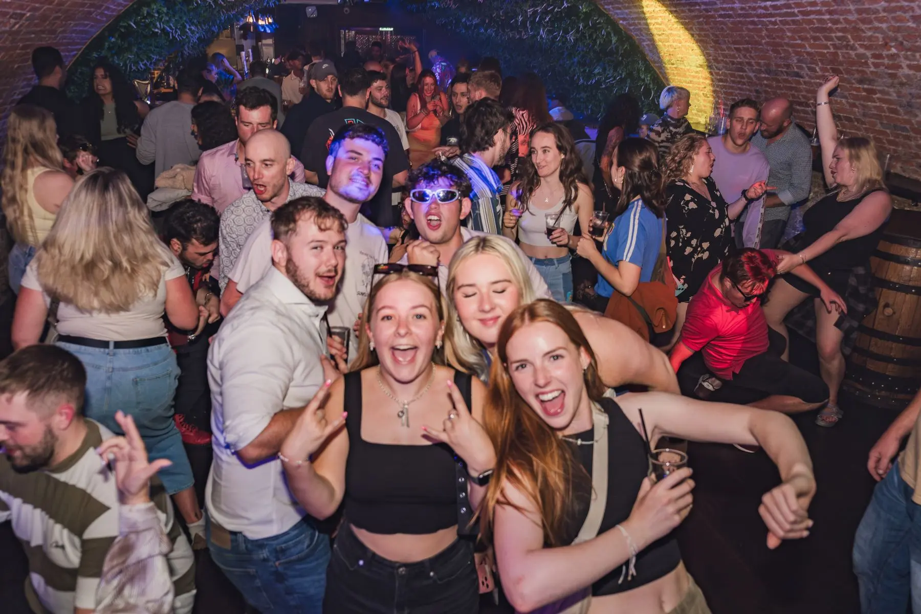 Happy revellers posing for the camera on a crowded nightclub dancefloor